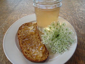 Image of Queen Anne's Lace Jelly Jar with slice of bread and a Queen Anne's Lace flower on a white plate.